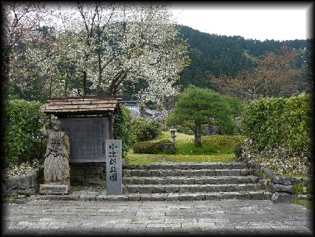 佐々木小次郎生誕地の入口に設けられた銅像と石造標と石段